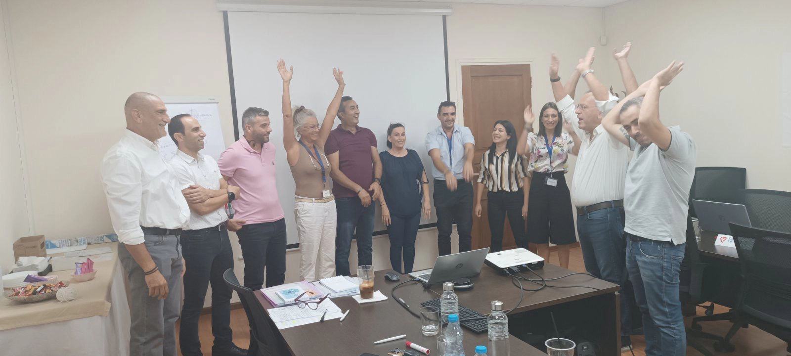 Workshop participants celebrating at the end of the seminar, standing and raising their hands in joy.